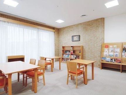 壁側に雑誌や本が置かれた本棚が設置され、自由に読書をして過ごせるフリースペース