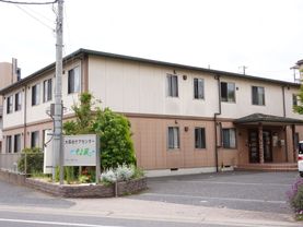 施設は地上２階の建物。敷地の入口には大きな施設の看板と沢山の植物や花が植えられている。道路と敷地の境目に段差がない。
