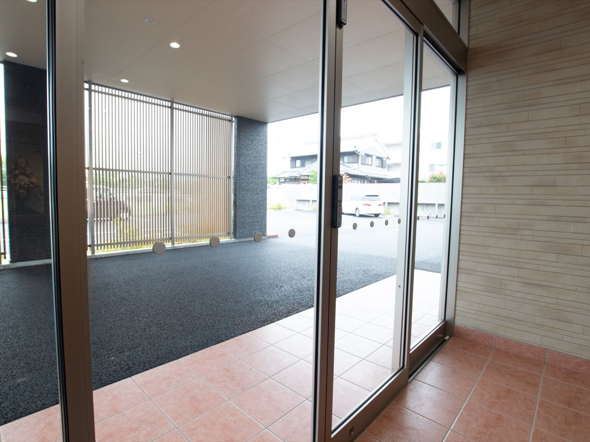 入口は自動ドアになっている。入口の外には大きなひさしがあり、施設前まで道路がアスファルト舗装されている。