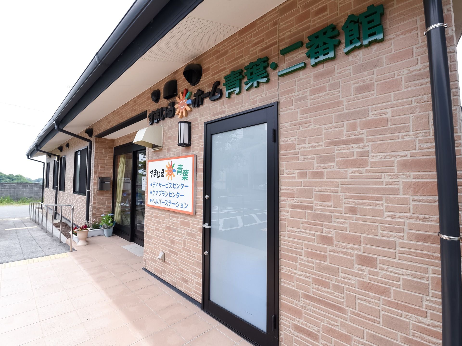 レンガ調の外観の平屋建ての建物である。入り口の壁に大きく施設名が書かれている。入り口には、階段とスロープで上がれる。