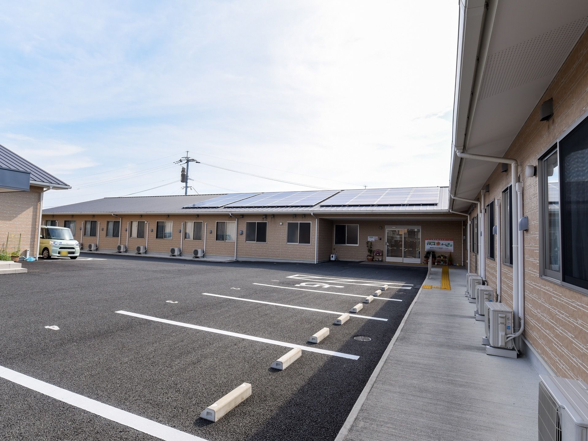 施設は平屋建てであり、屋根にソーラーパネルが設置されている。駐車場が広く取られており、多くの車が収容できる。