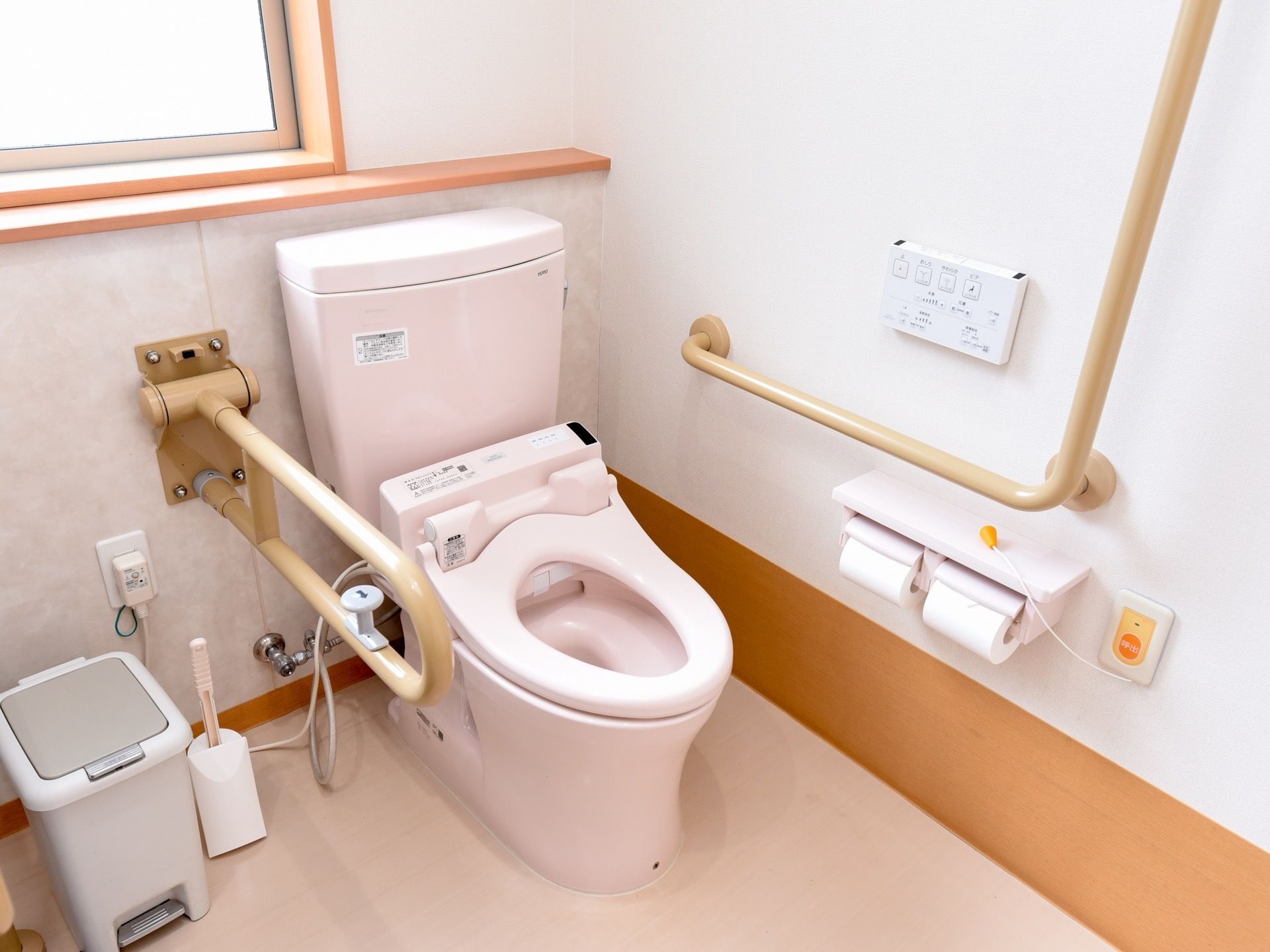 トイレの壁に手すりが設置されている。呼び出しボタンも付いていて、押すか紐を引っ張ることでスタッフを呼び出すことができる。