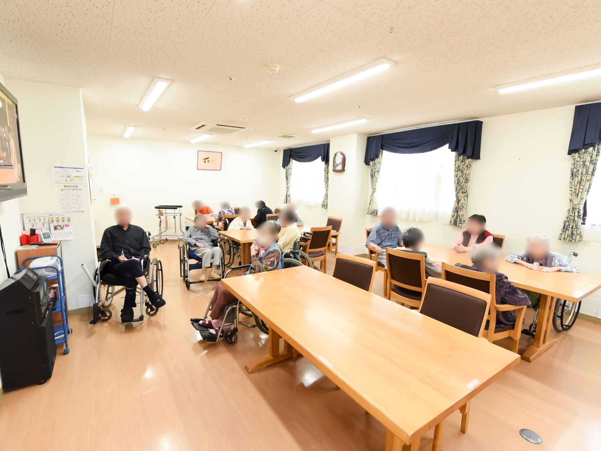 食堂の右端には腰高窓があり、白いレースとリーフ柄のカーテンが掛けてある。天井には、細長い照明器具が付いている。