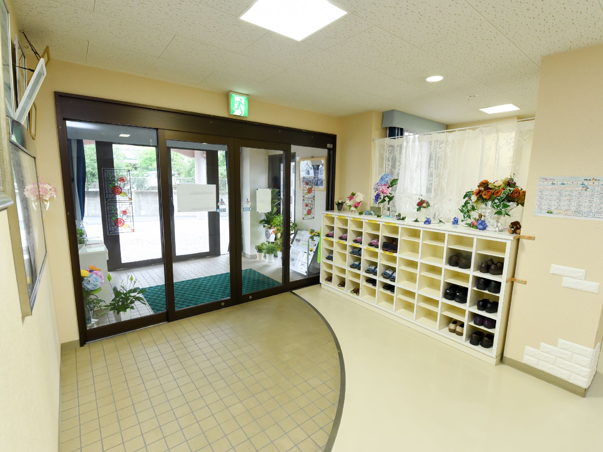 あちこちに植物が置かれ、収納力のある下駄箱が設置されたエントランスホール