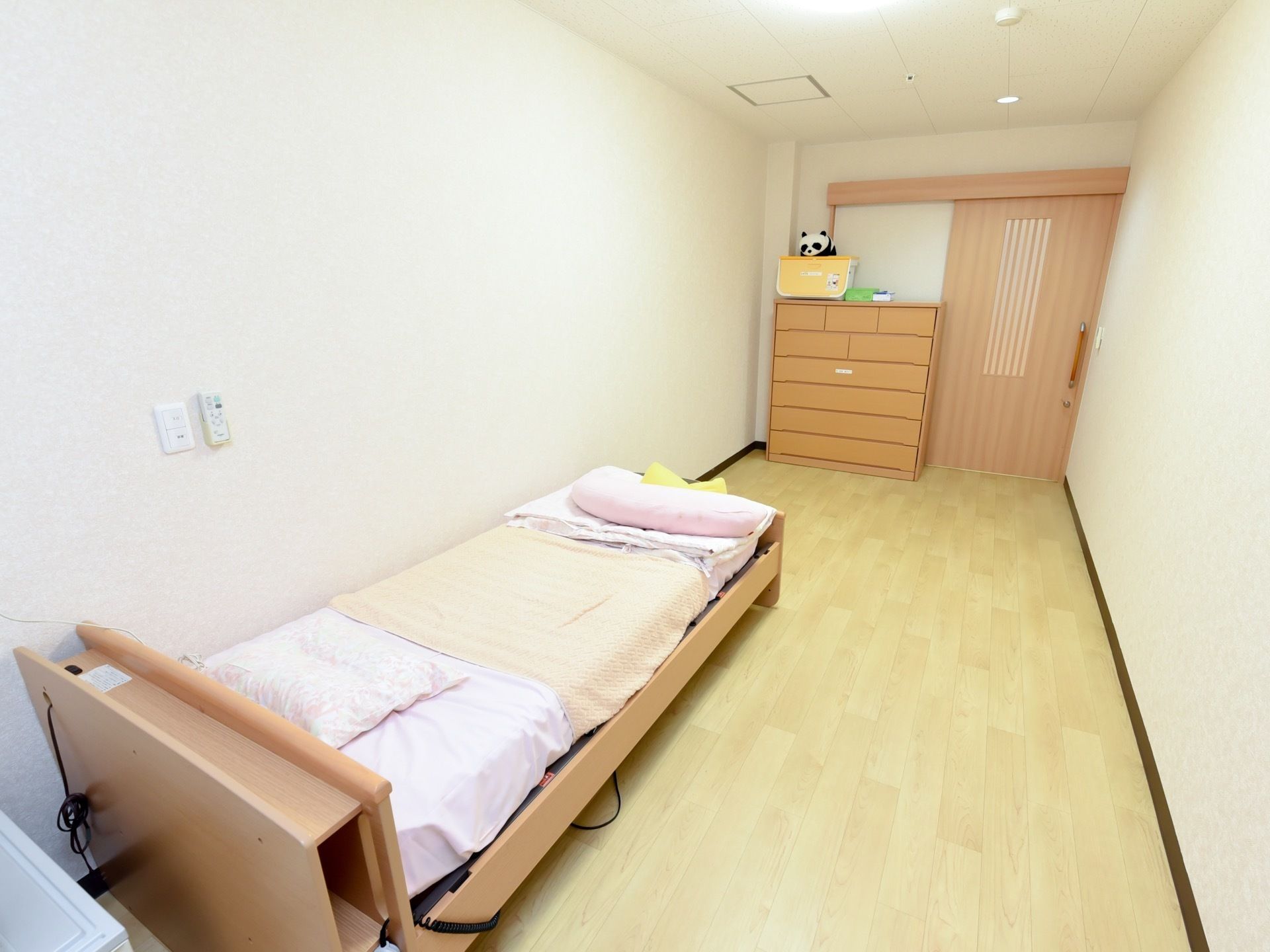 白い壁紙でお部屋の雰囲気は明るくなっている。また、リクライニング機能付きのベッドはお体が不自由な方でも起き上がりやすくなっている。