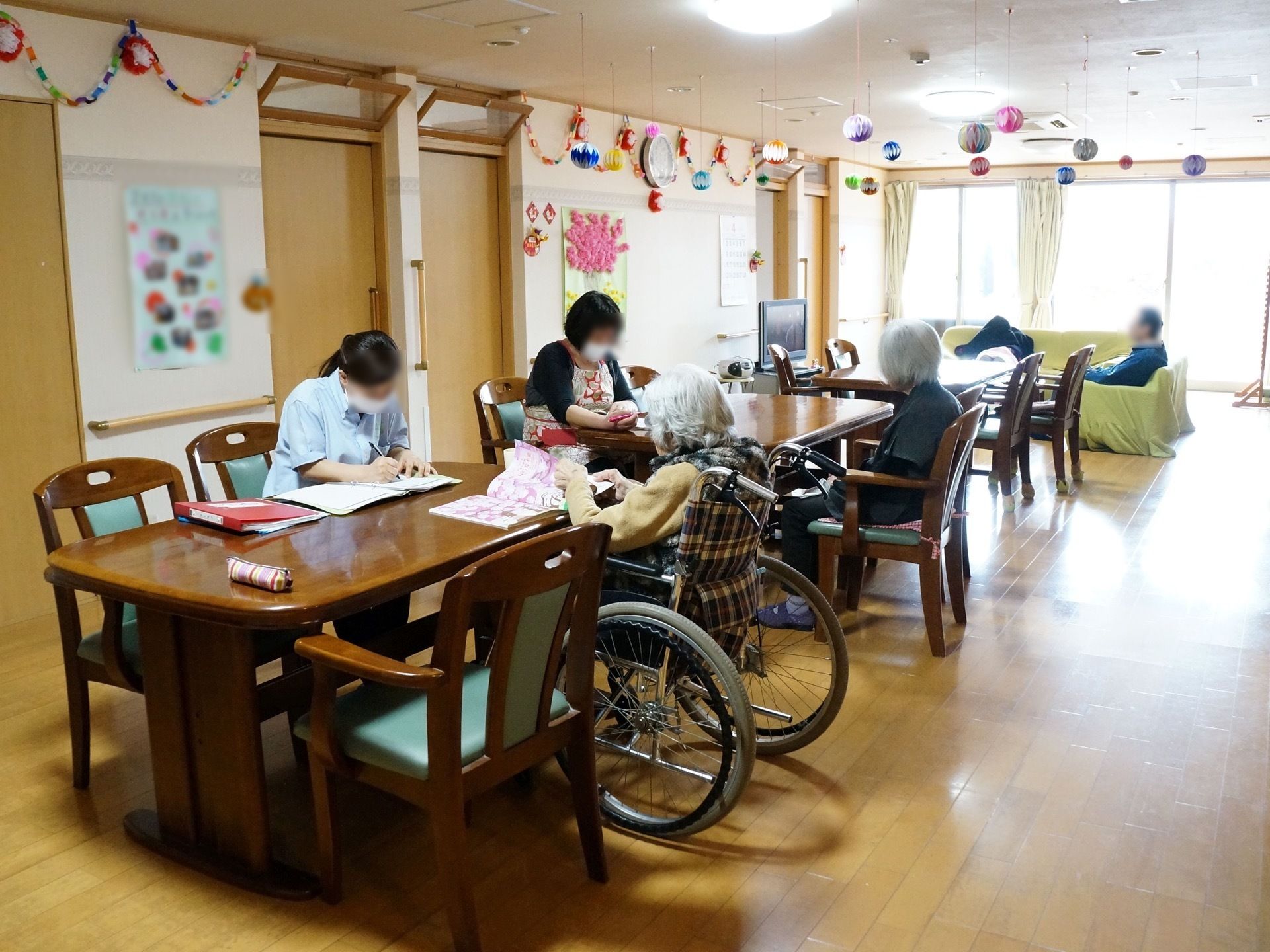 入居者様とスタッフが向かい合って座り、読み書きをしている風景