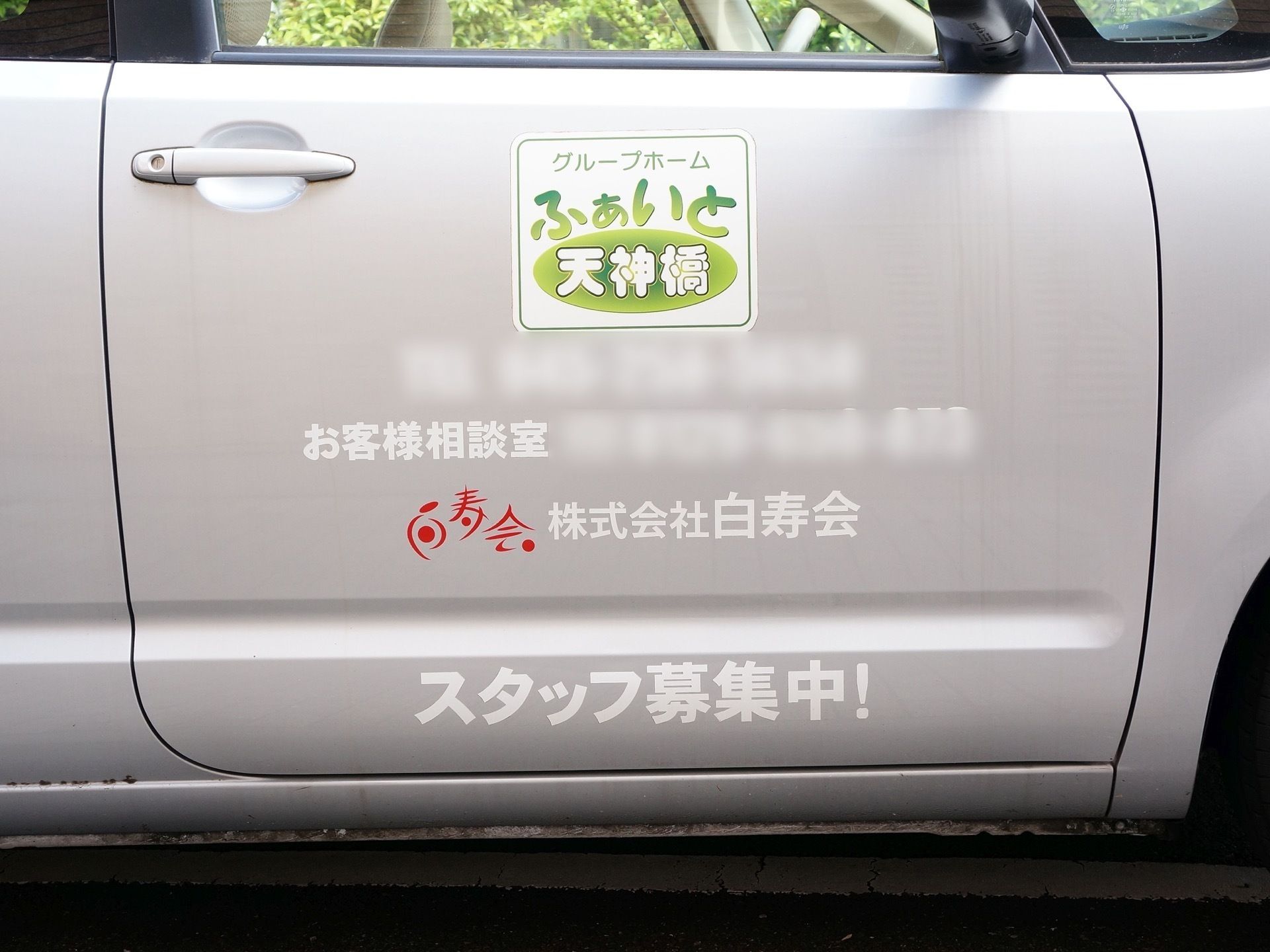 運転席側のドアに、白字と赤字で会社名が記載された施設専用の車