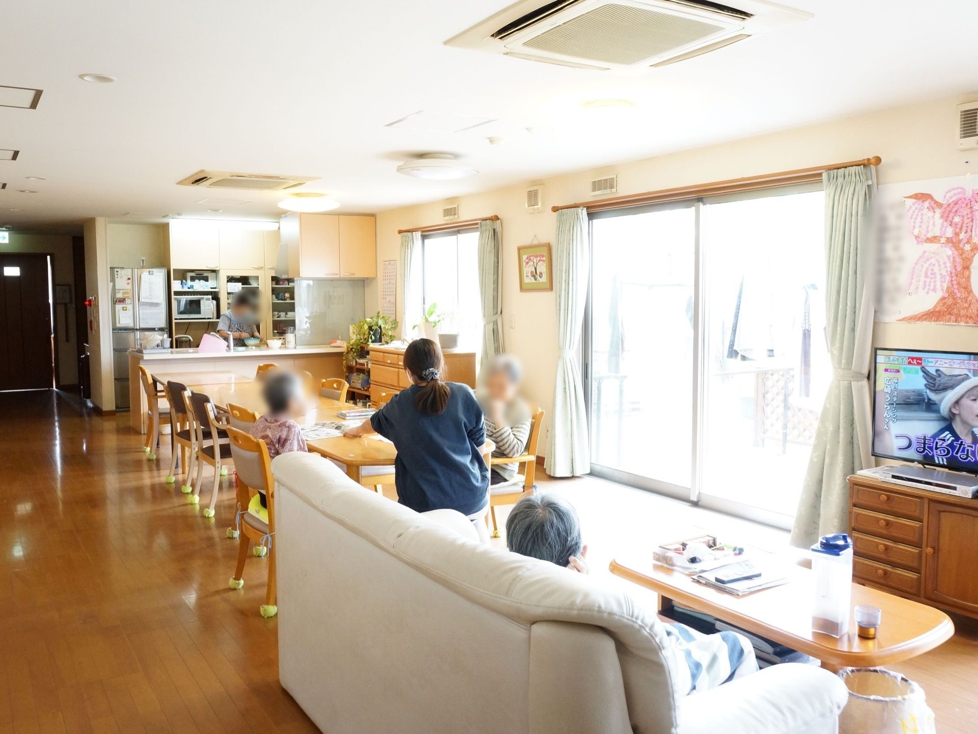 お食事スペースの横にソファーやカフェテーブル、テレビが置かれている。ベランダに続く、大きな窓がある。