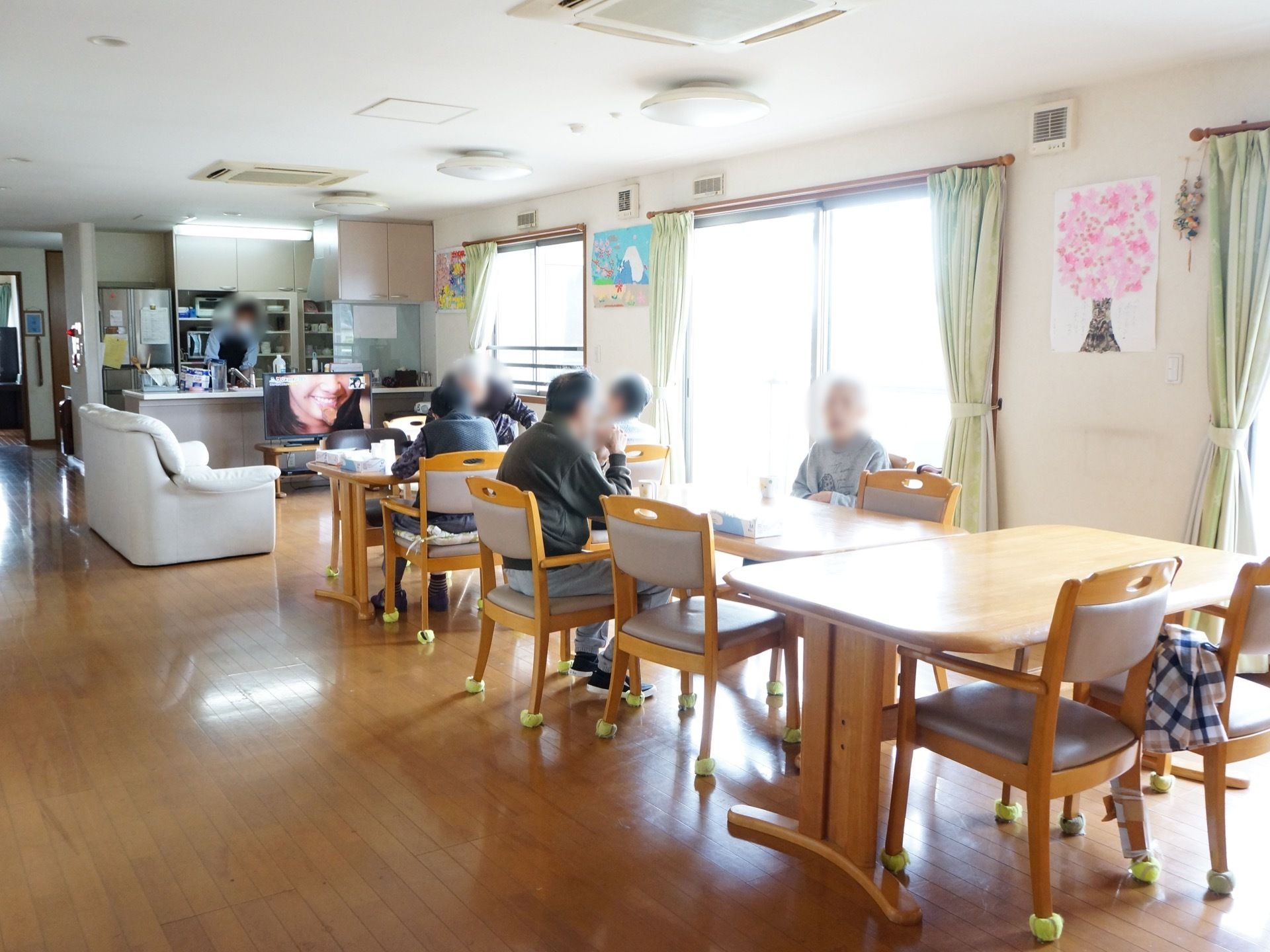 廊下との仕切りがない、非常に明るくて開放的な共有スペースである。床は木目調のフローリングになっている。