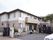 ２階建ての大きな一軒家のようなグループホームで周りは柵で囲まれている。施設の前には駐車スペースが確保されている。