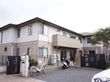 ２階建ての大きな一軒家のようなグループホームで周りは柵で囲まれている。施設の前には駐車スペースが確保されている。
