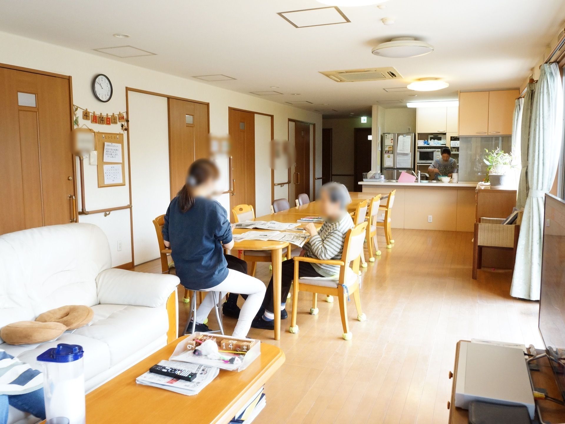 女性の入居者様と女性の介護スタッフが向き合って談笑する多目的室