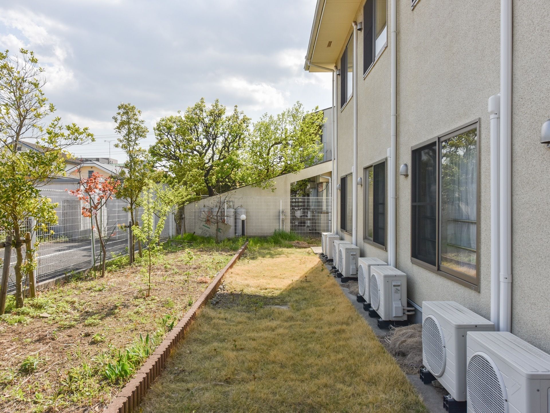 庭は丸太型のブロックで、通路側と植え込み部分との２つに区切ってある。室外機を置く場所はコンクリートである。