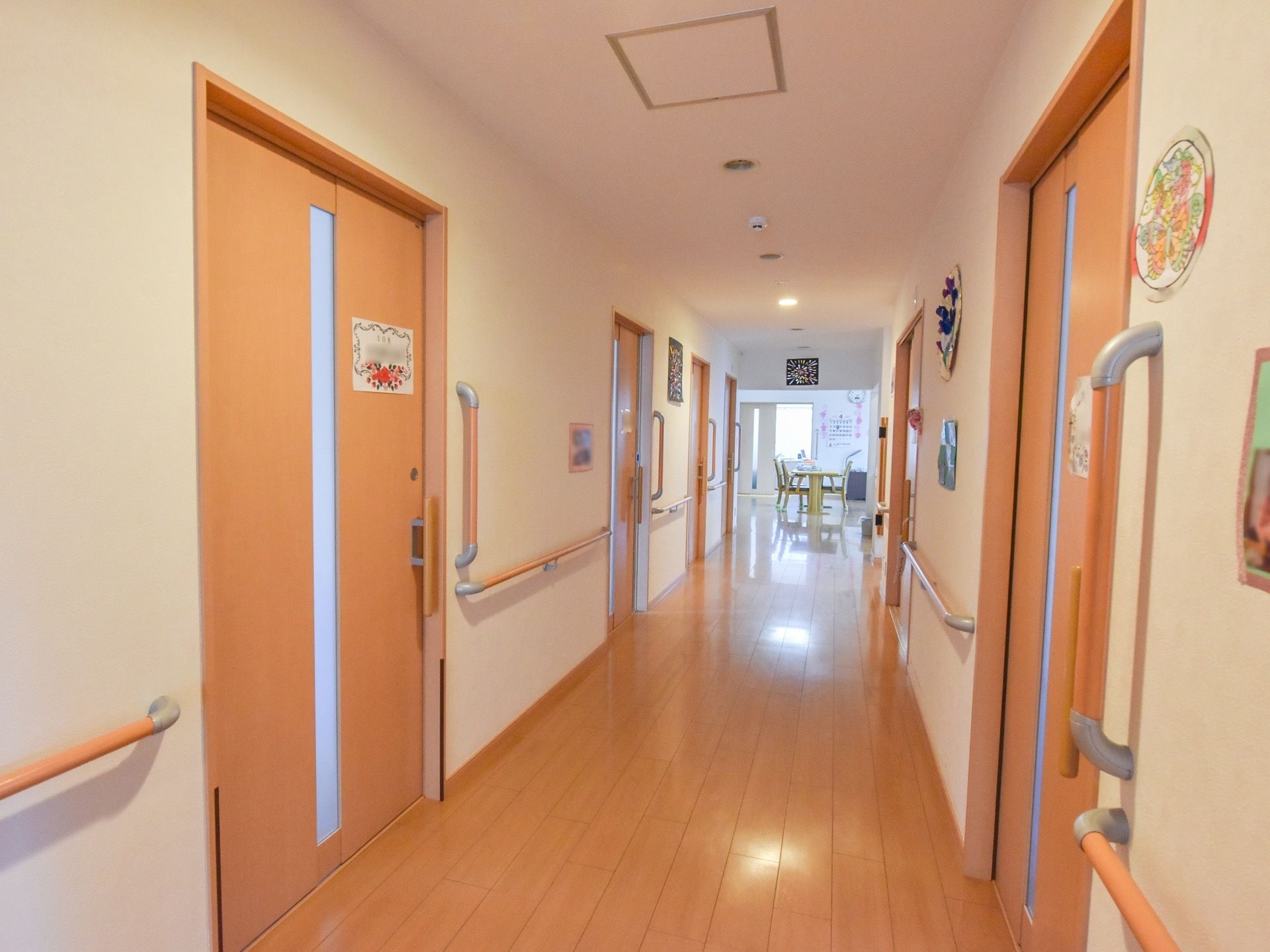 廊下には居室のドアが並んでおり、天井と壁には花をモチーフにした飾りが多くかけてある。ドアの横には手すりを設置している。