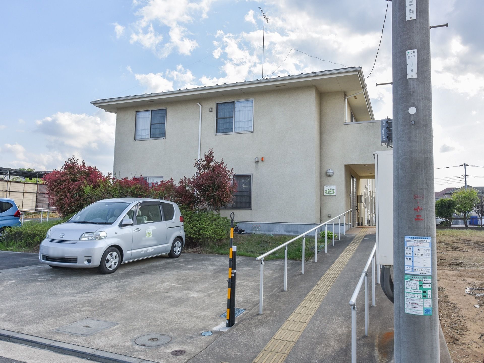駐車場から玄関へと向かう場所に、スロープが設置してある。両側に掴まることができるバーがあるほか、地面に黄色い点字ボードがついている。