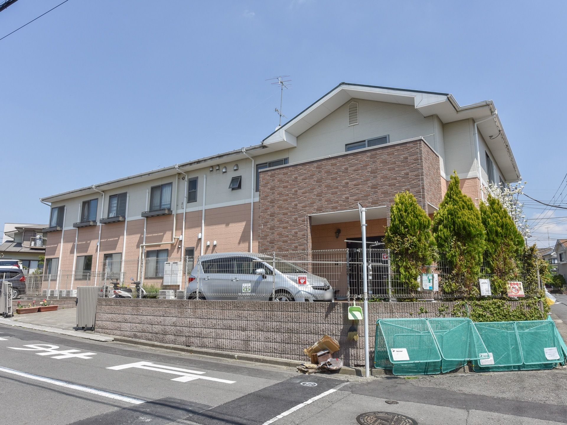 施設は一見すると、一般的な戸建てを大きくしたような造りになっている。施設前がゴミ置場になっているので、ゴミ出しの負担が少なくなっている。