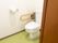 広々としているトイレがある。便座の横には手すりが設置されていて、壁には緊急通報装置がつけられている。