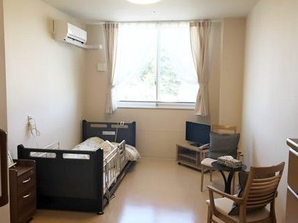 ベッドが見やすい場所にテレビが設置され、外からの光が差し込む居室