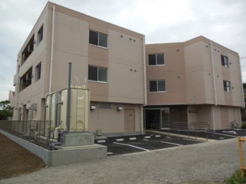 玄関まで手すり付きの通路が伸びており、玄関部分の外壁形状が内に窪んだ外観の建物