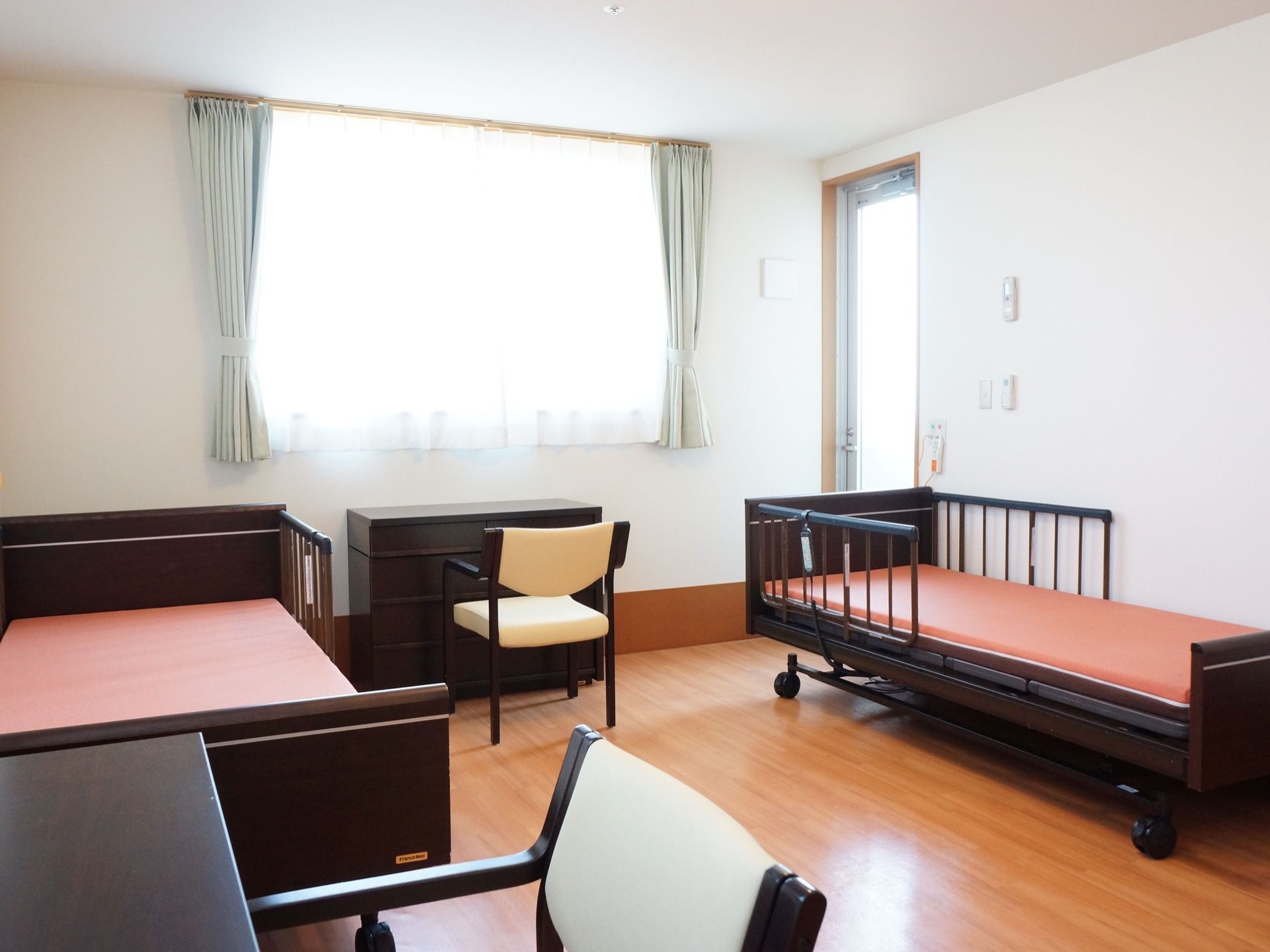 二人用の居室。ベッドや机などは備え付けになっている。また、ナースコールも設置済み。窓もあり、明るく広い空間である。