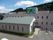 手前には白を基調とした平屋の建物がありその奥に白の施設の敬寿園が建っている。裏には木々が生い茂った山が見える。