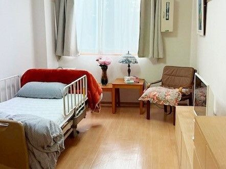 床に直接腰を落ち着けて過ごすことのできる和の要素も持ち合わせた居室である。室内にはベッドが設置されている。