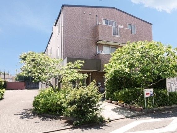 施設はレンガ調の3階建ての建物である。建物の周辺各所に草木が植えられている。施設の入口までは白地の平坦な路面が続いている。