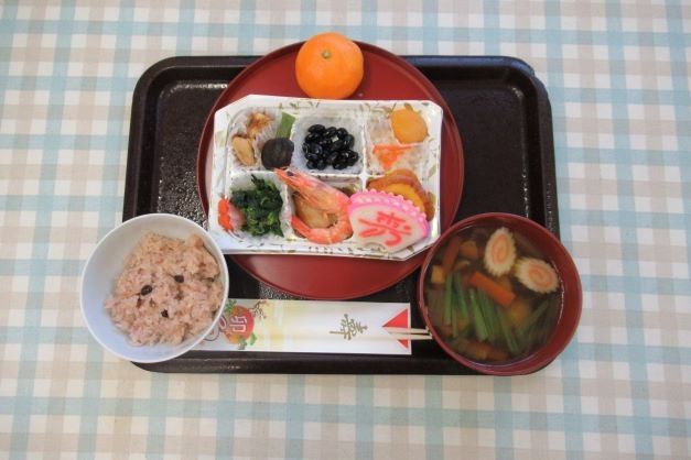 四角いお皿にカニやうなぎ、だて巻きなどが載っている