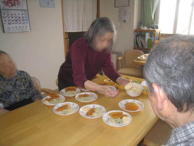 女性ケアマネジャーの話を聞く高齢女性