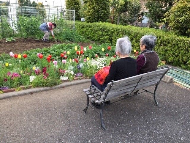 車椅子に乗った高齢女性と向き合う女性ヘルパー
