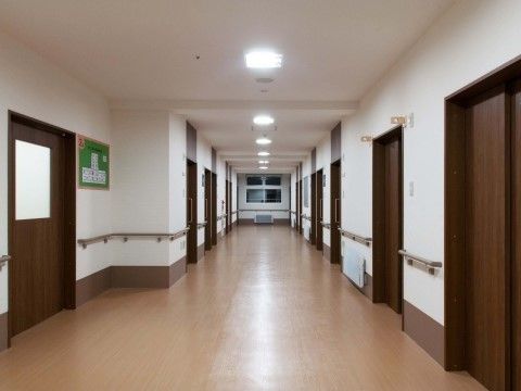廊下の横幅は広くとられている。両側にドアが並んでいるが、手前左のみ壁が凹んでおり、そこにガラス窓付きの大きな引き戸がある。