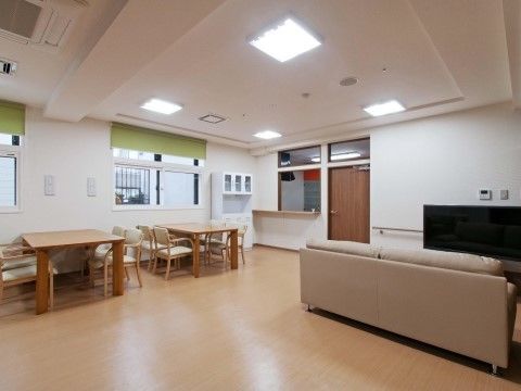 テレビを正面に据えたソファ席と木製のテーブル席が、部屋の両側に分けて配置された部屋