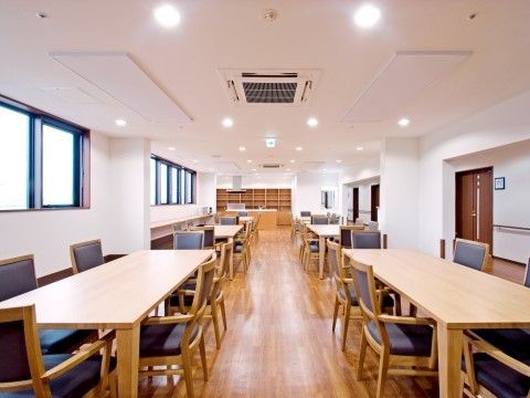 奥行きのある多目的室である。入居者様の動線を考慮したテーブルの配置になっており、安心して通行することが可能である。