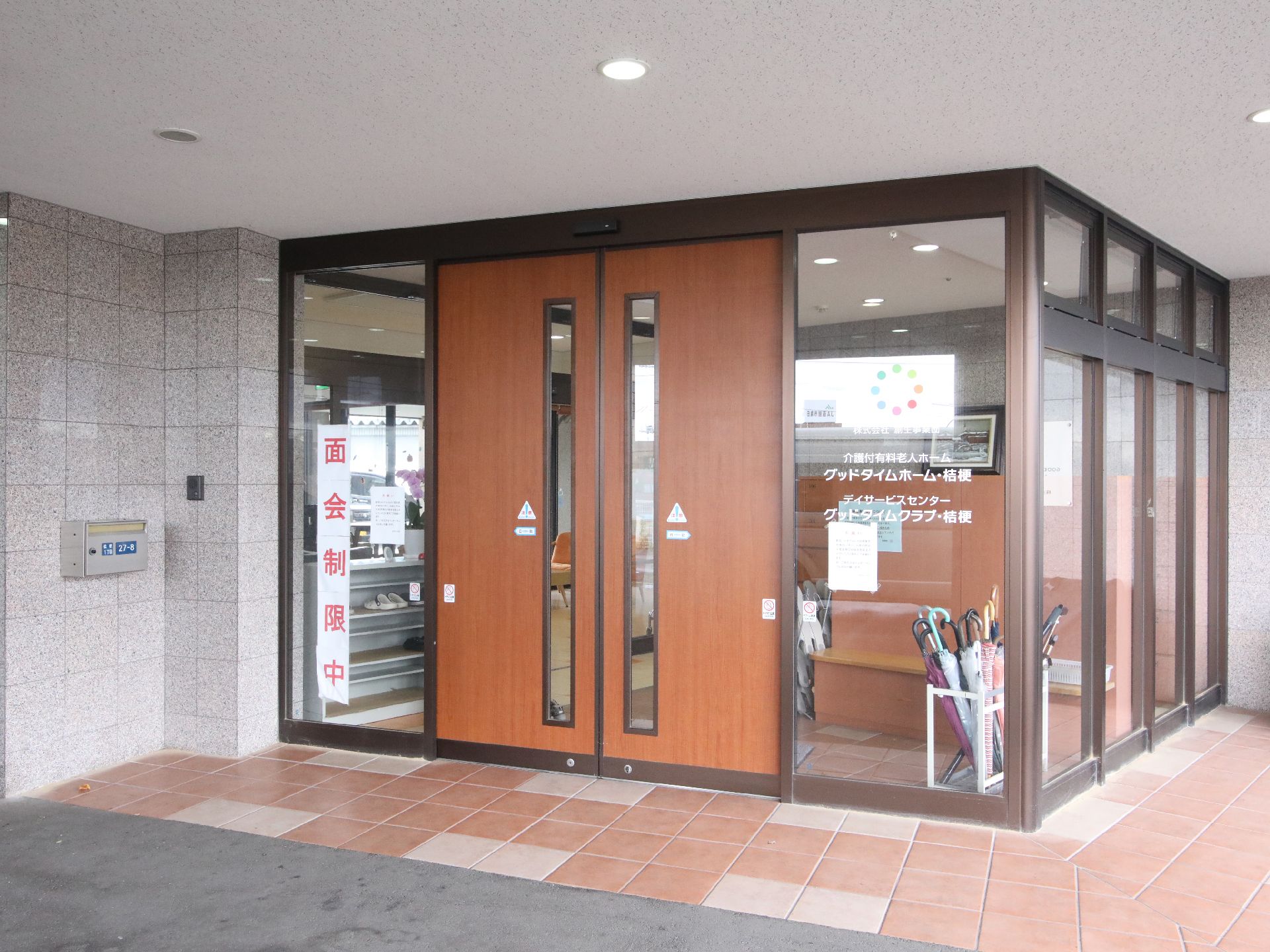 ナースステーションの入り口で、微笑みながら廊下の方向を見る看護師姿の女性たち