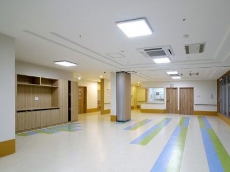 廊下との間に仕切りや段差のない、開放的なリビングである。大きな柱が１本立っており、奥にカウンターが見える。