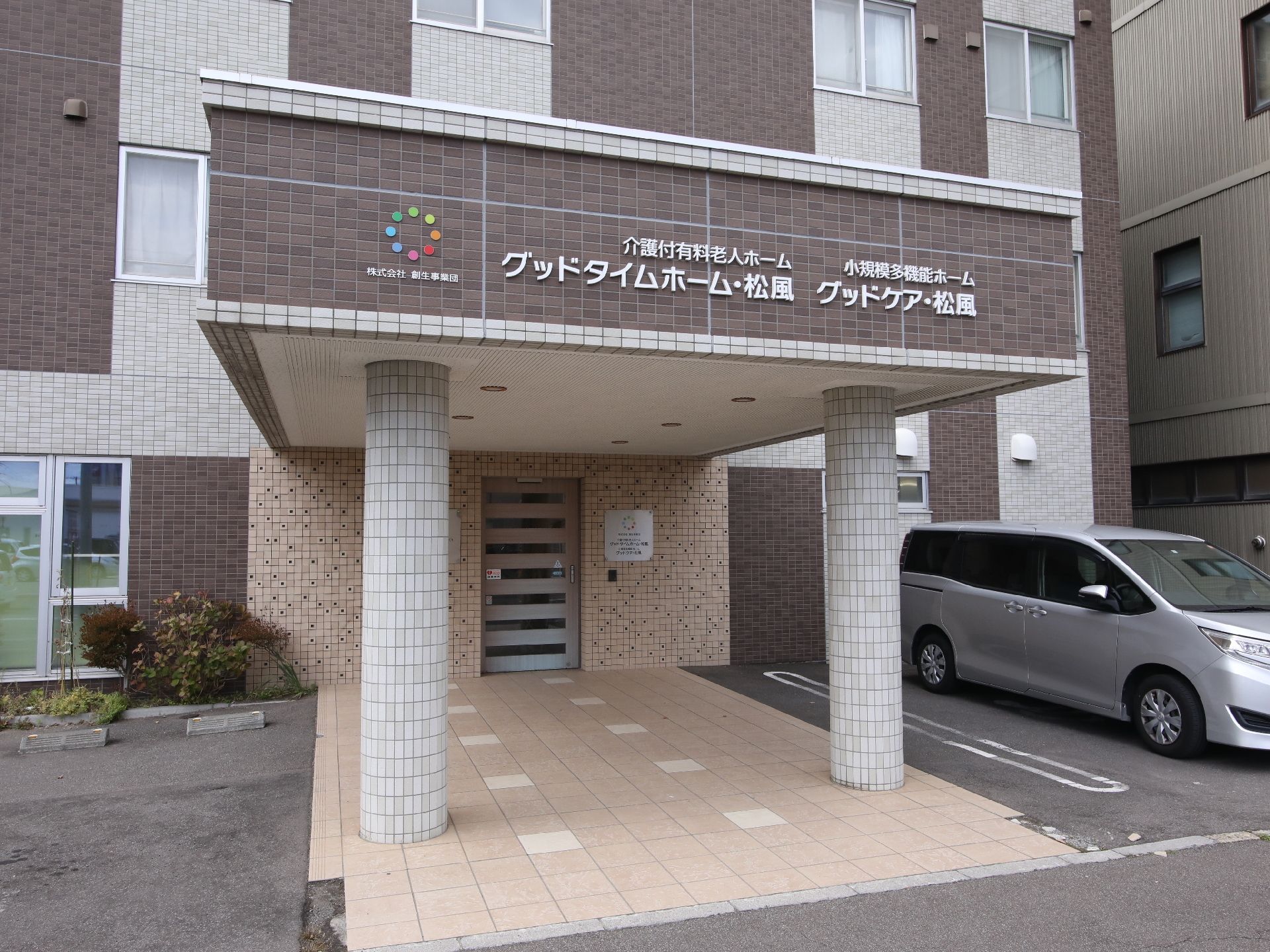 診察机に座り、高齢の男性に向かい合って話をする白衣姿の男性