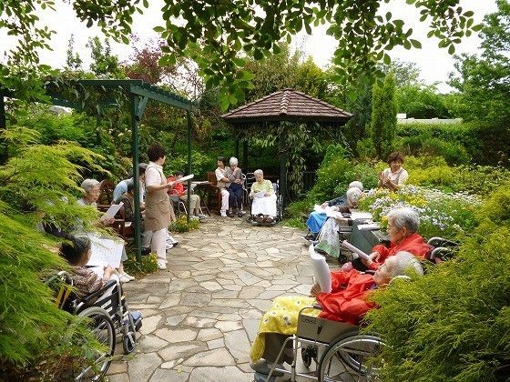 イングリッシュガーデン風の庭に集まり、イベントを楽しむ入居者の皆様