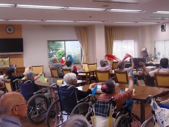 演奏に合わせて、手に持ったカラフルな布を振る入居者の皆様