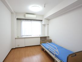明るい白が基調の居室には、ナースコールが付いていたり、高さの低い転落防止のベッドが設けられ、安心安全である。