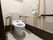 白を基調とした清潔感のあるトイレである。背もたれをはじめ、立ち座り時のサポートになるレバーが完備されているので、快適である。