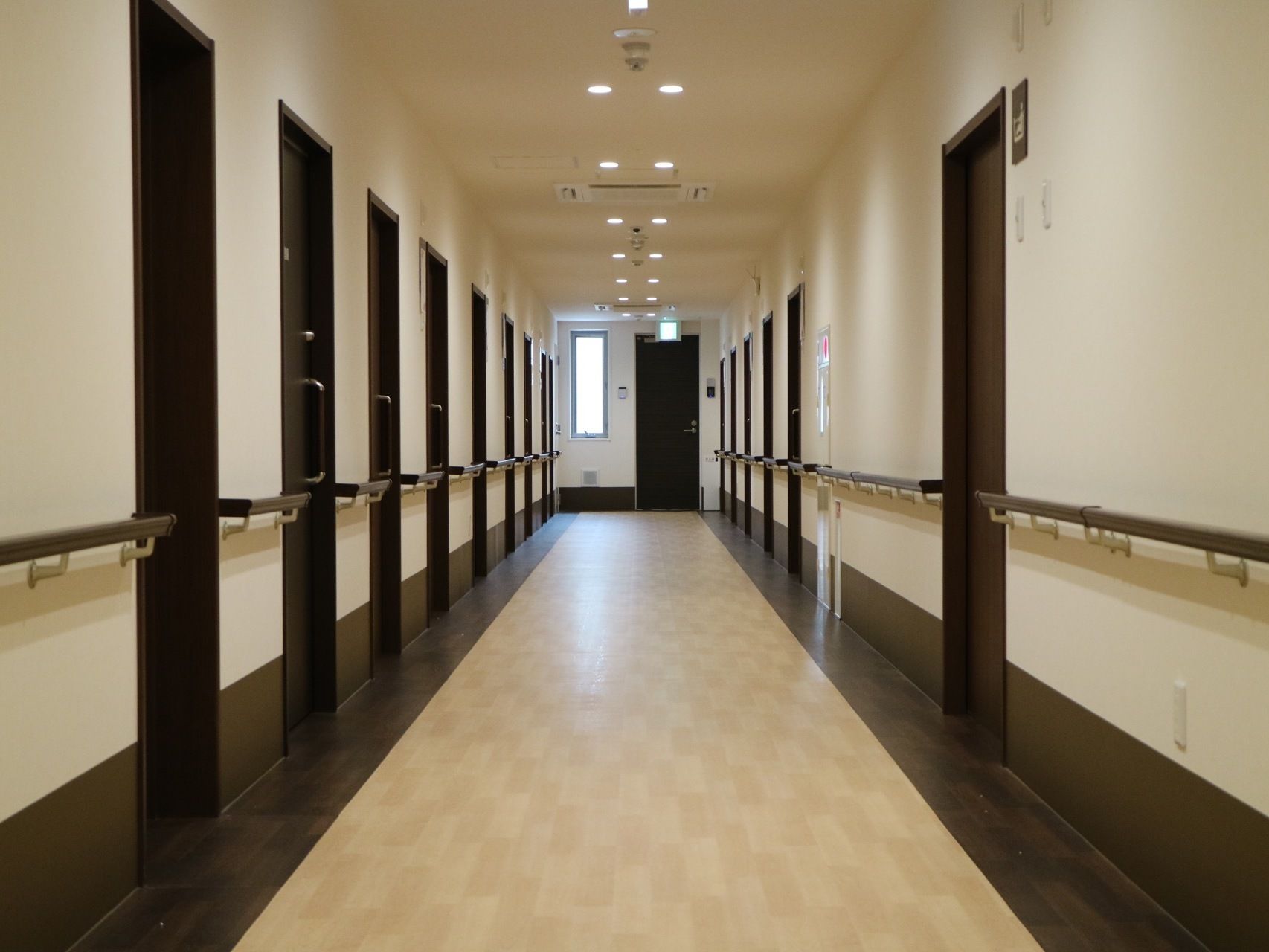 落ち着いた雰囲気の明るい廊下である。幅が広く取られており、左右の壁に沿って手すりが取りつけられている。