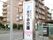 道路に面した所に、運営グループ名と施設名が書かれた、白地で縦長の施設看板が設置されている。運営会社のロゴが目立っている。