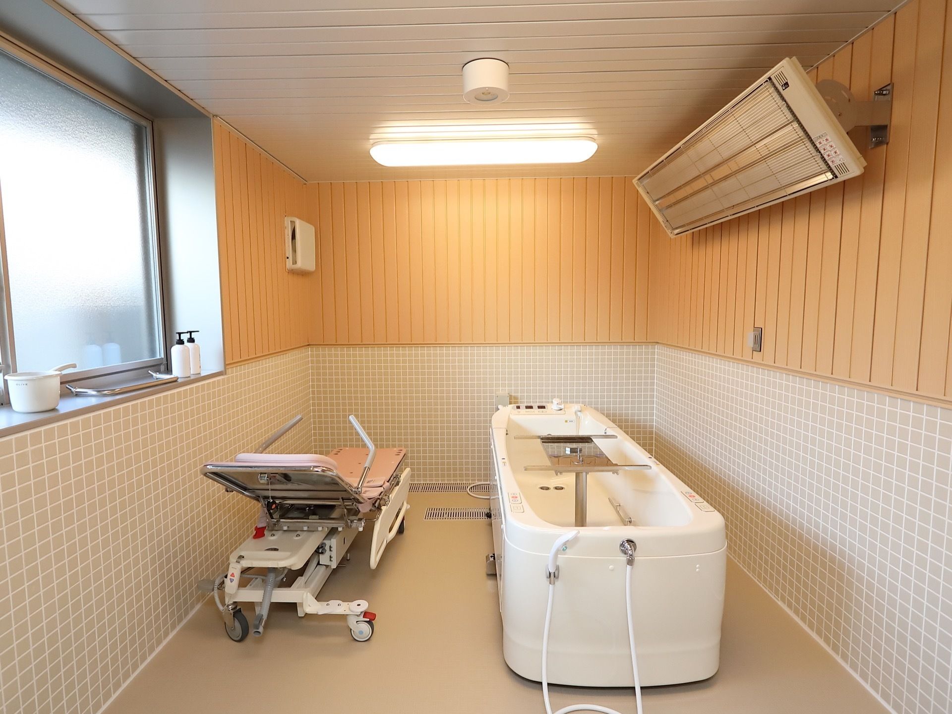明るく開放的な浴室には機械浴槽と浴室用のストレッチャーが配置されている。入居者様に入浴介助のサービスを提供している。