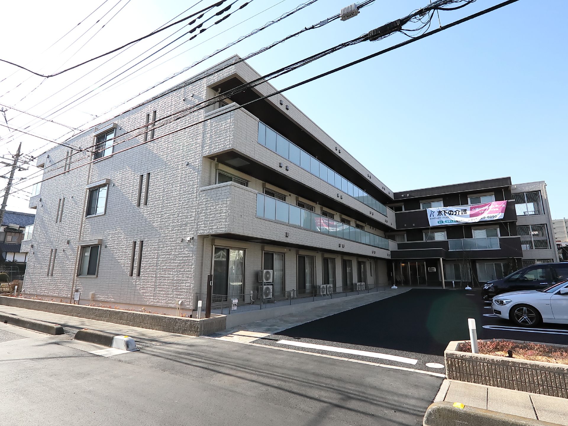 白い壁の建物が写っているパース。駐車場スペース建物のパース