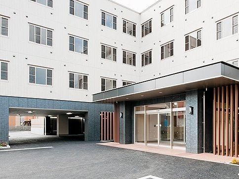 1階部分が藍色のピロティになっている、４階建ての建物