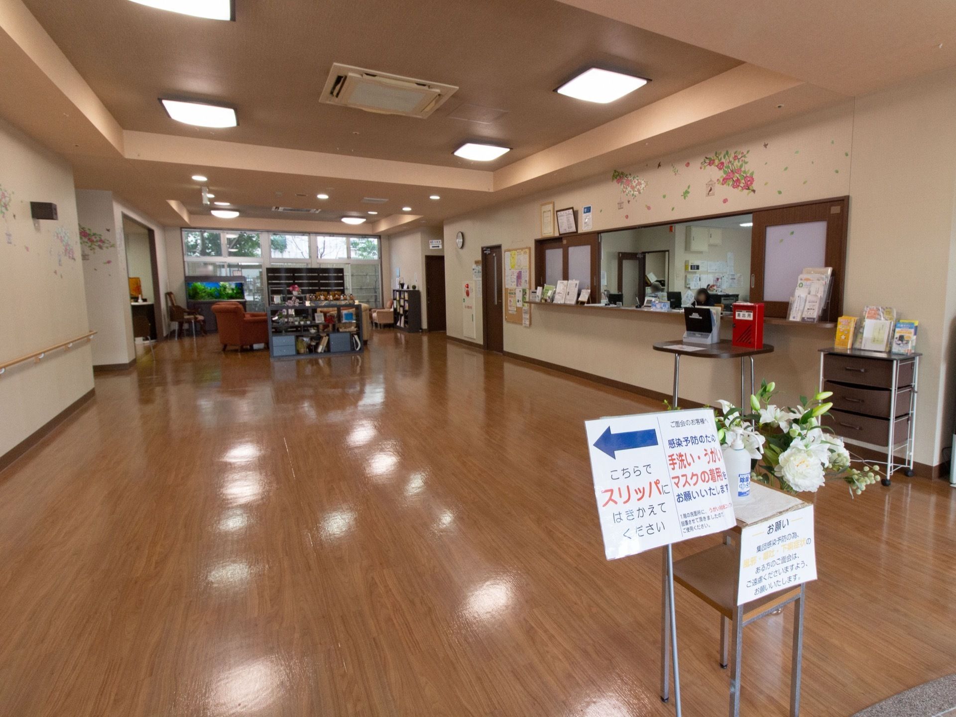 広々とした開放感のあるエントランスである。消毒用のアルコールが置かれている。右手にはスタッフが常駐する受付がある。
