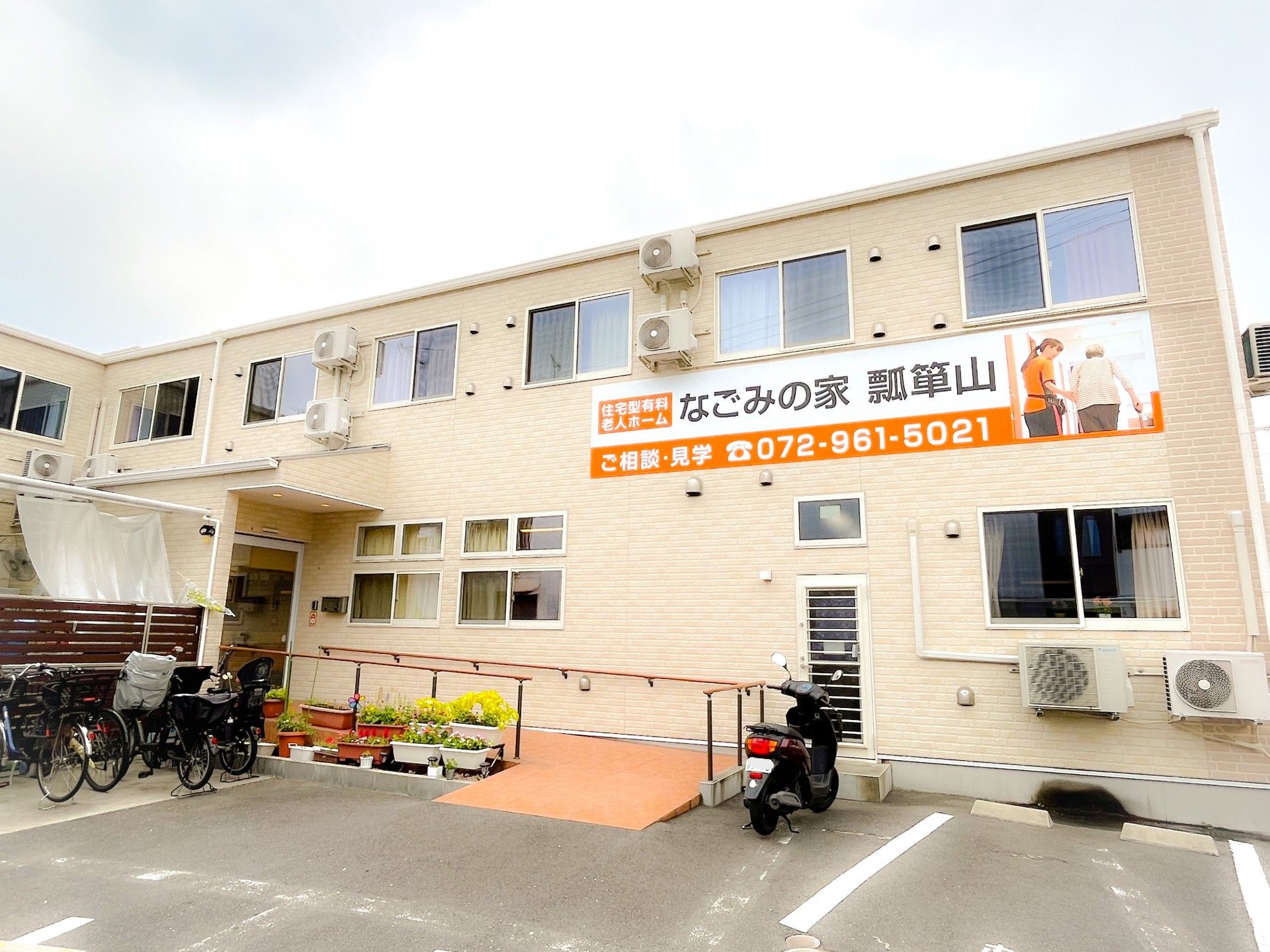 ２階建ての大きなグループホームである。施設内には駐車場があり、車椅子をご利用の方専用のスペースも確保している。