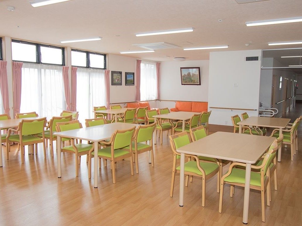 大きな窓があり明るい光が差し込む食堂には４人掛けテーブルが６組ある。奥にはソファー席も用意されている。
