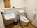 トイレには、背もたれのついた補助具が付いている。自動の手洗い用シンクと、紙タオルが備え付けられている。