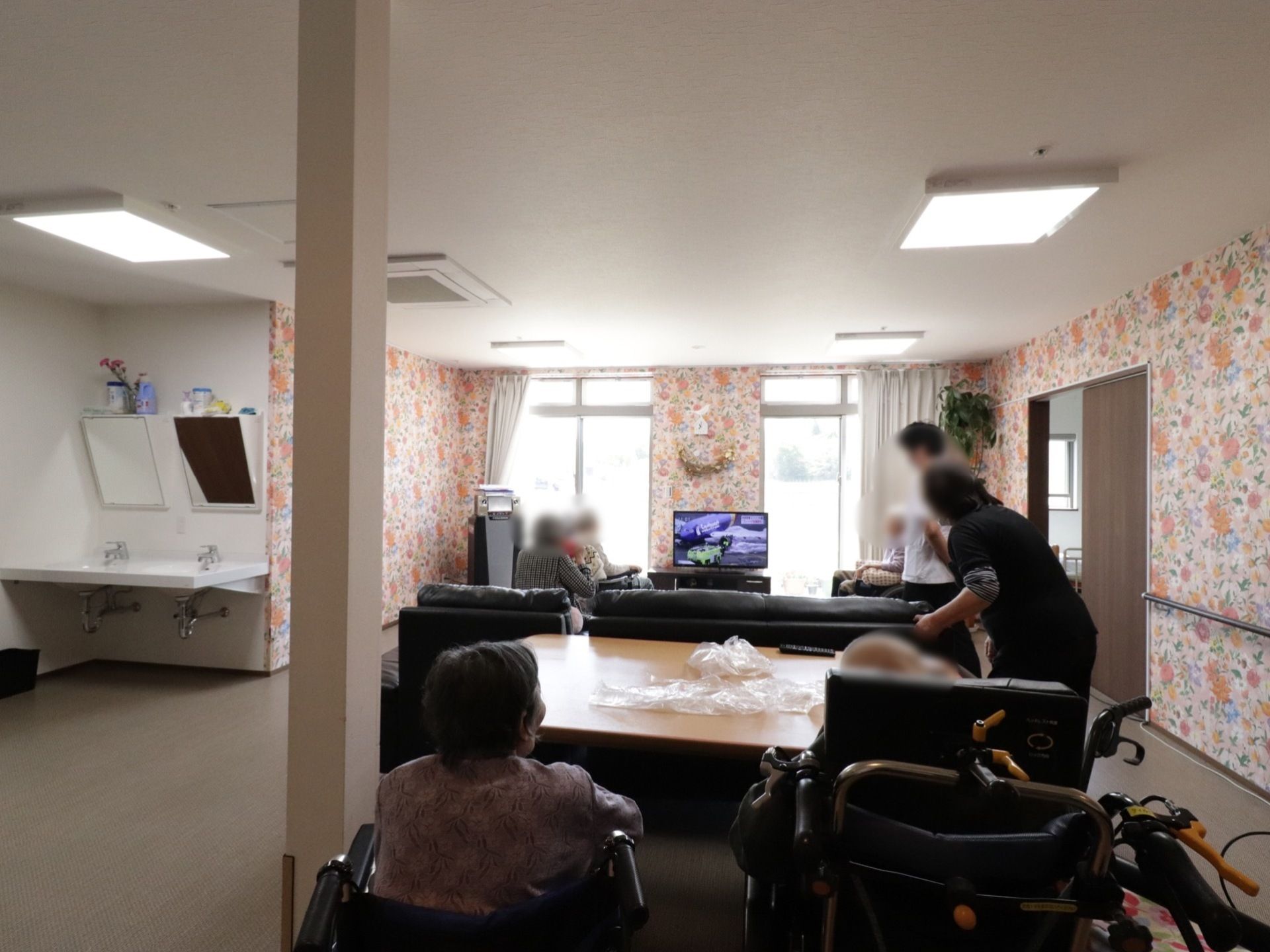 談話室の壁紙は華やかな花柄で、入居者様が寛いで過ごせるようになっている。テレビを見たり、おしゃべりしたりと好きなことをできる。